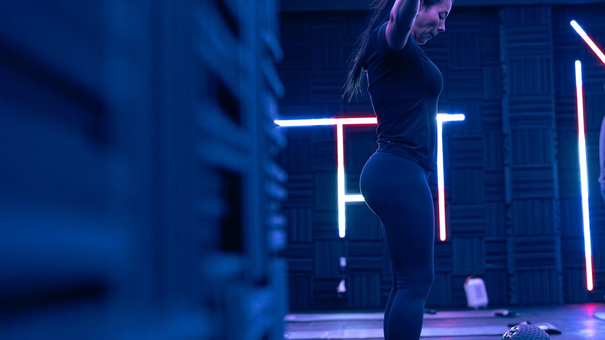 Fitness enthusiast exercising in a stylish neon-lit studio, embodying strength and focus.